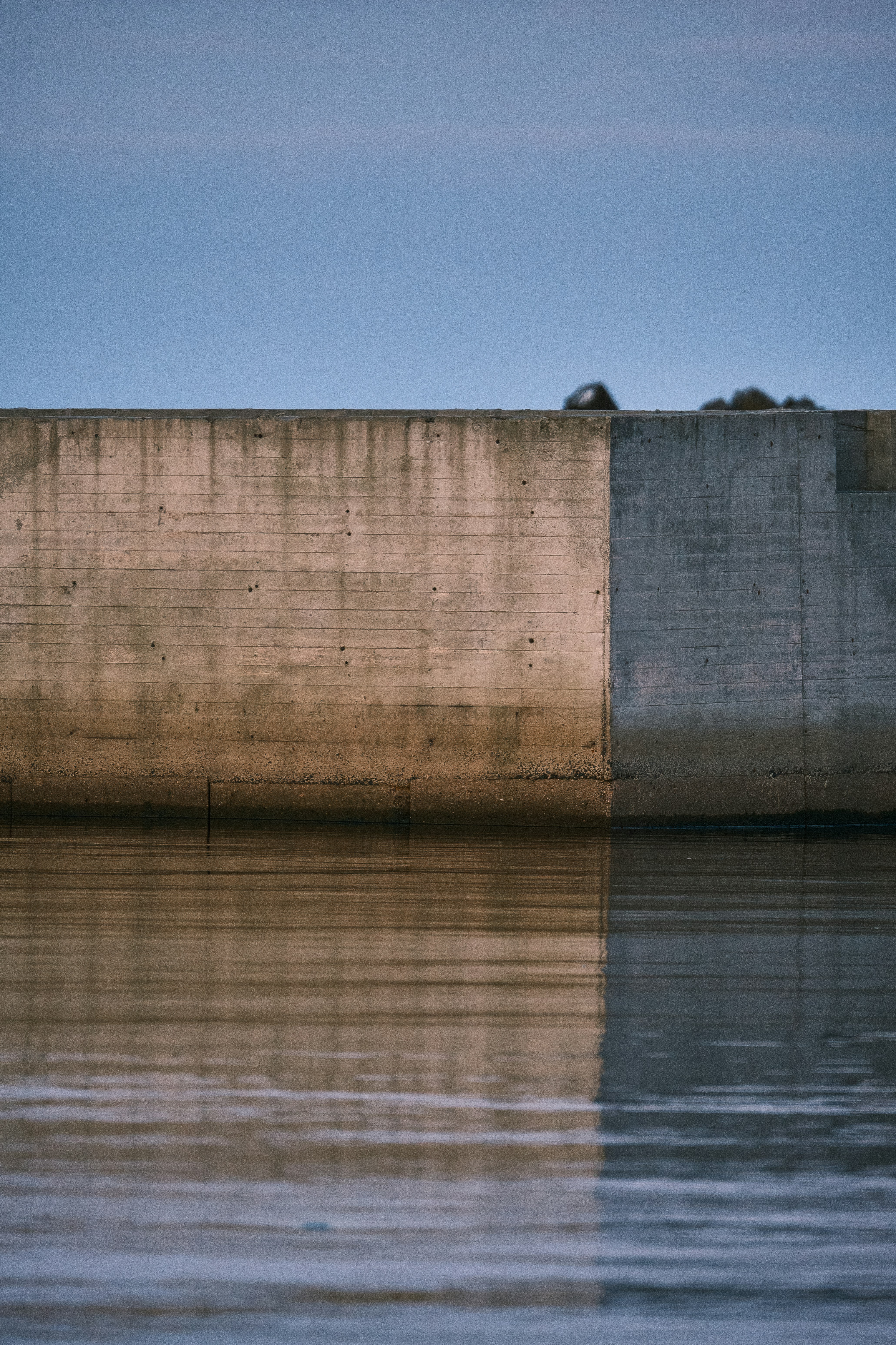 brown concrete wall near body of water during daytimeby Yuriy Mayatnikov