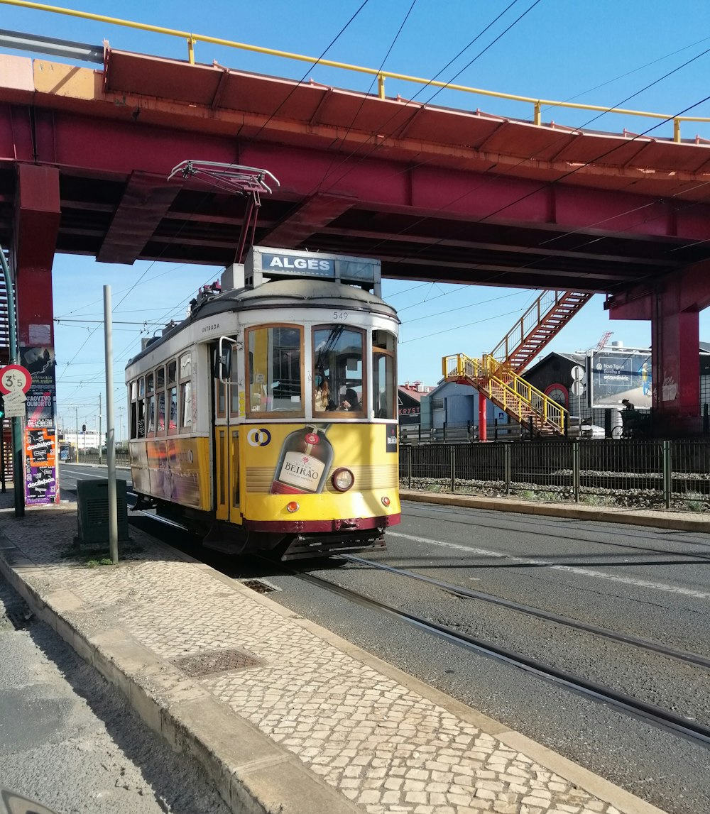 yellow and red train on rail tracks during daytime