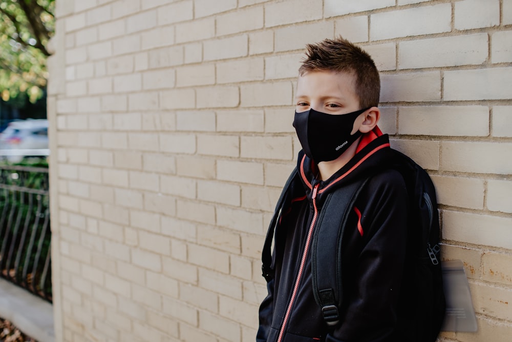 man in black jacket wearing white mask