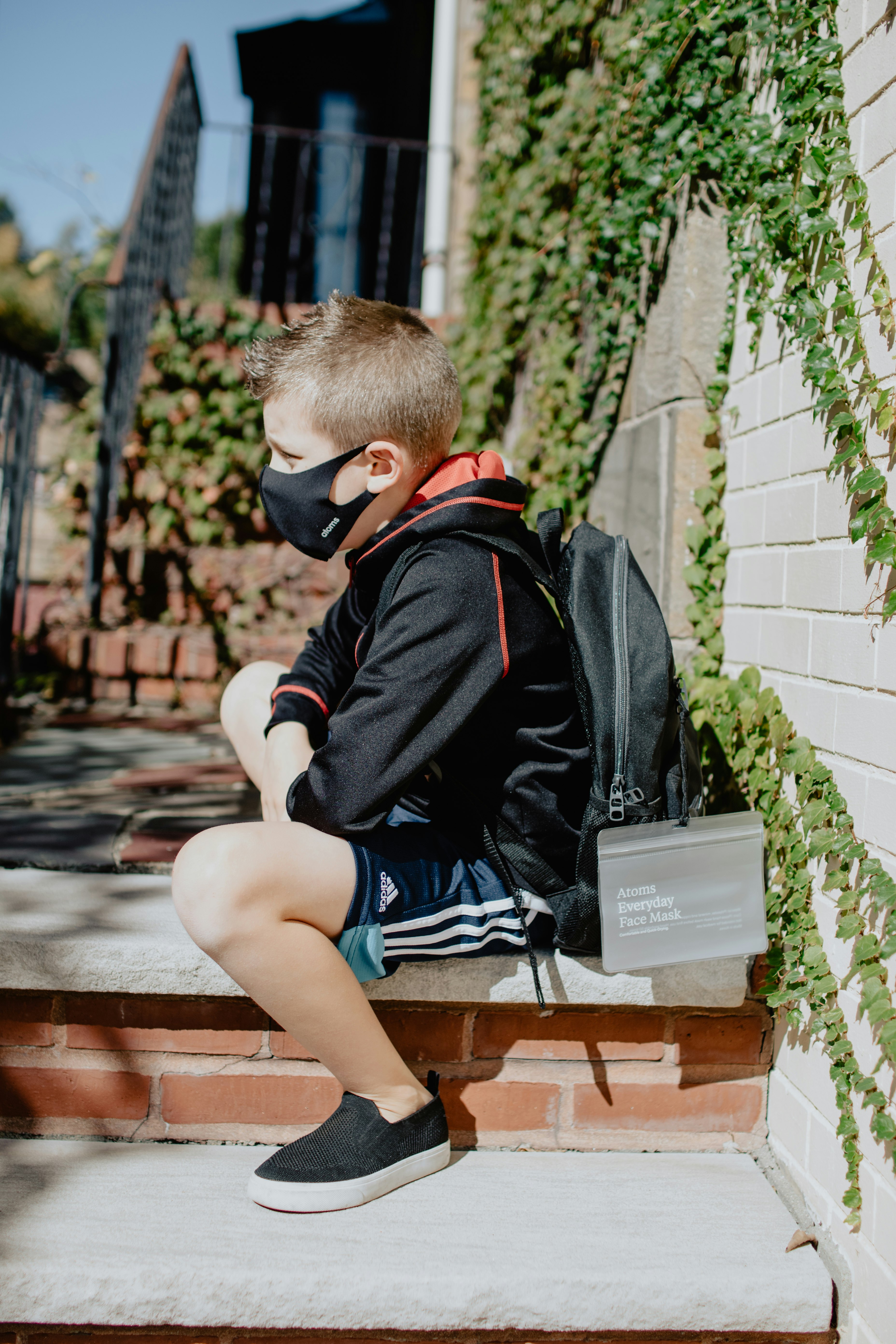 Boy sitting on a step with a mask on