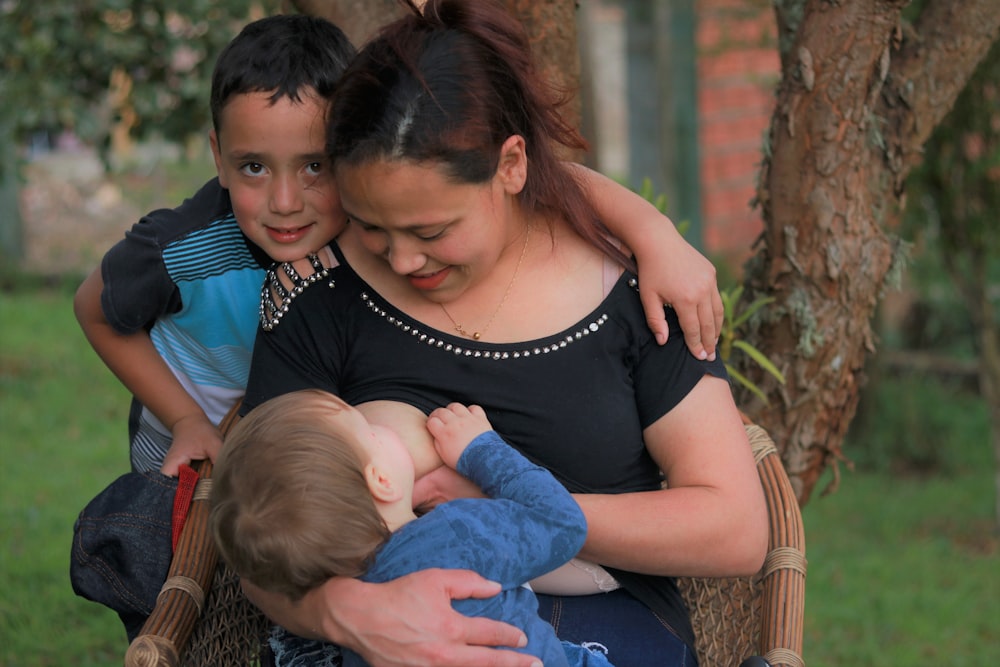 woman in black tank top carrying baby