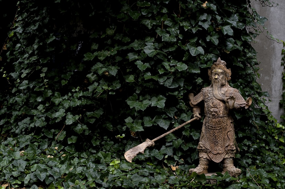 brown concrete statue near green leaves