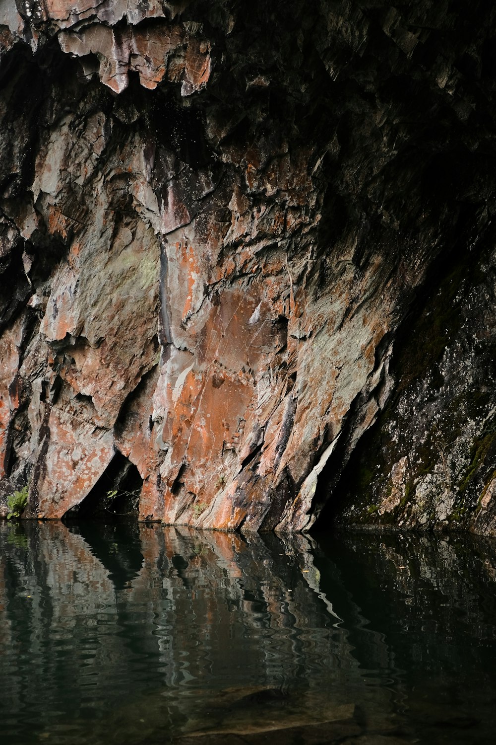 brown and gray rock formation beside body of water during daytime