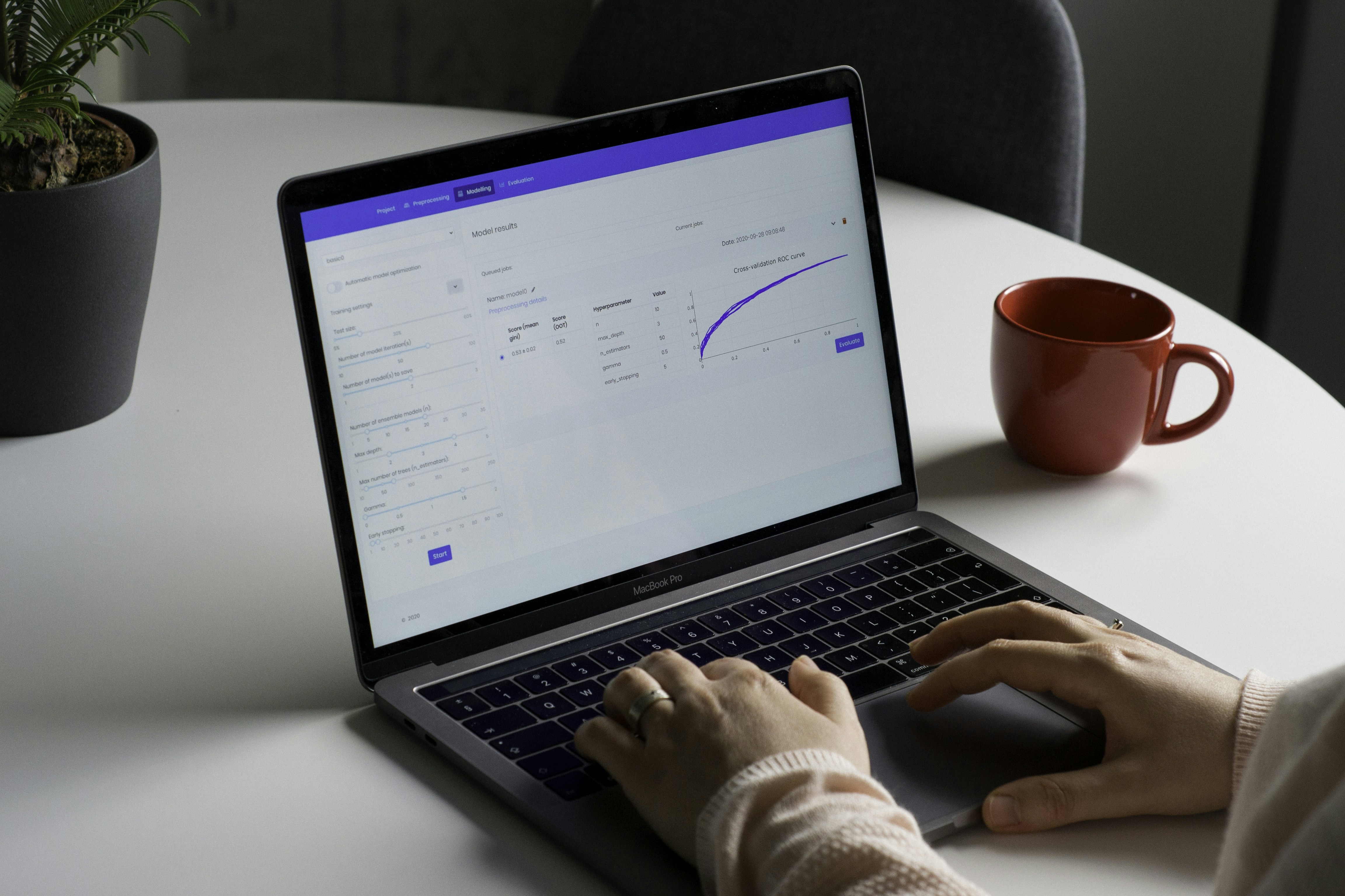 person using macbook pro on white table