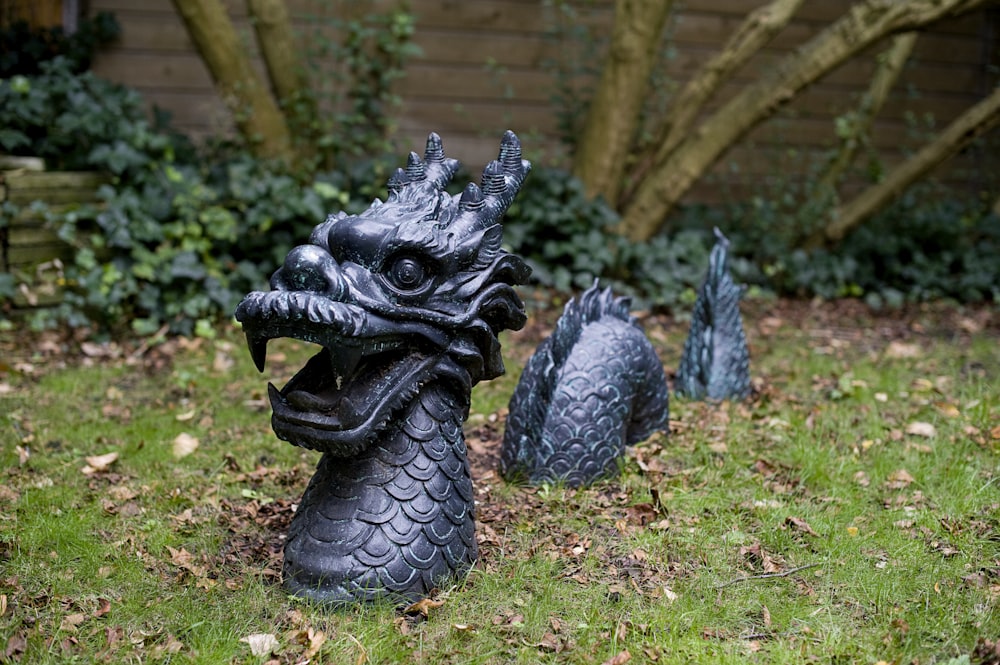 緑の芝生の上の黒いドラゴンの像