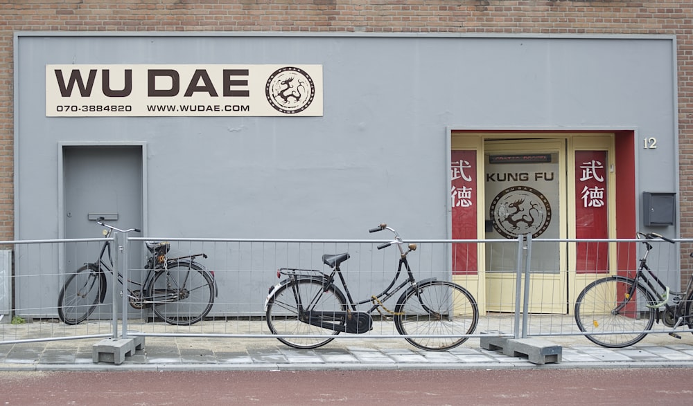 bici da città nera parcheggiata accanto al muro bianco