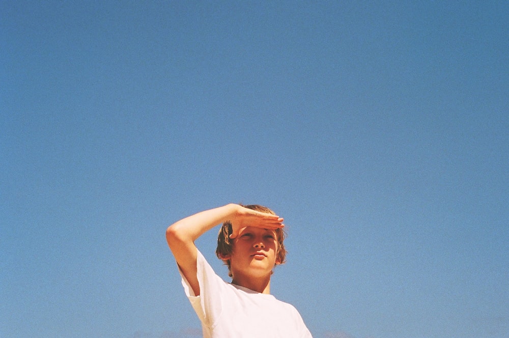 femme en chemise blanche sous le ciel bleu pendant la journée