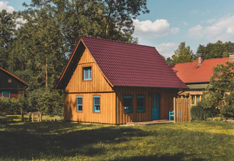 brown and white concrete house near green trees during daytime