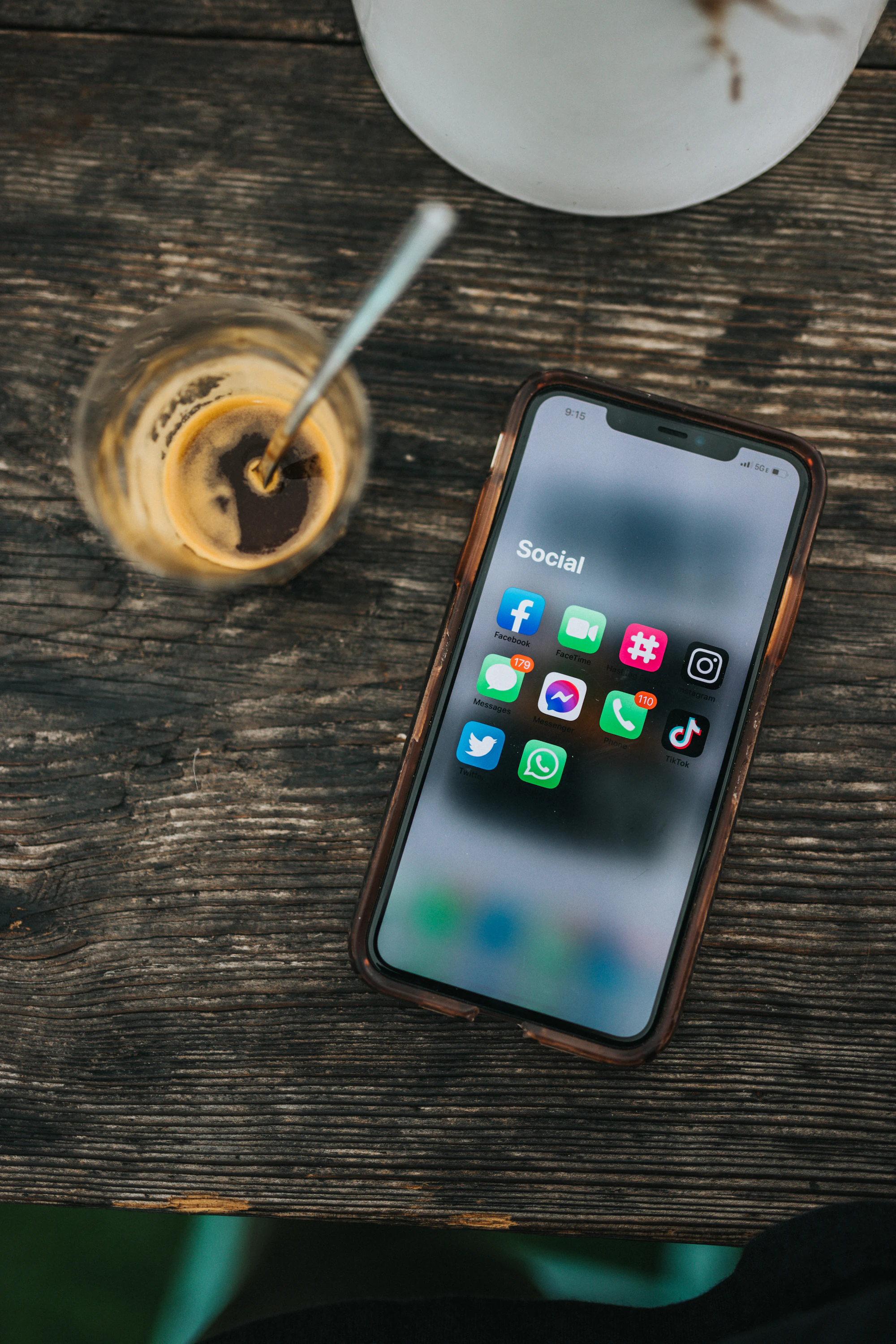Smartphone with social media apps beside a coffee