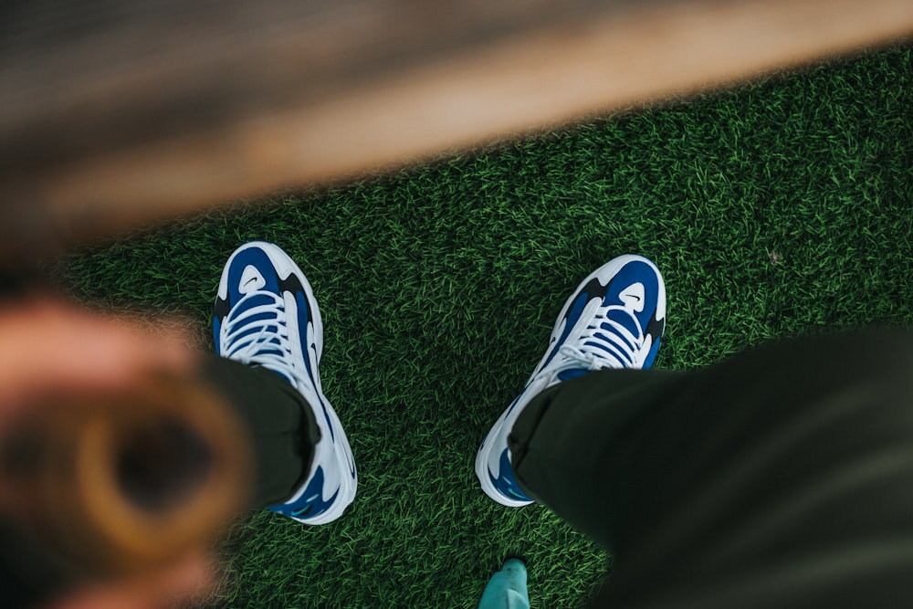 person in black and white adidas sneakers