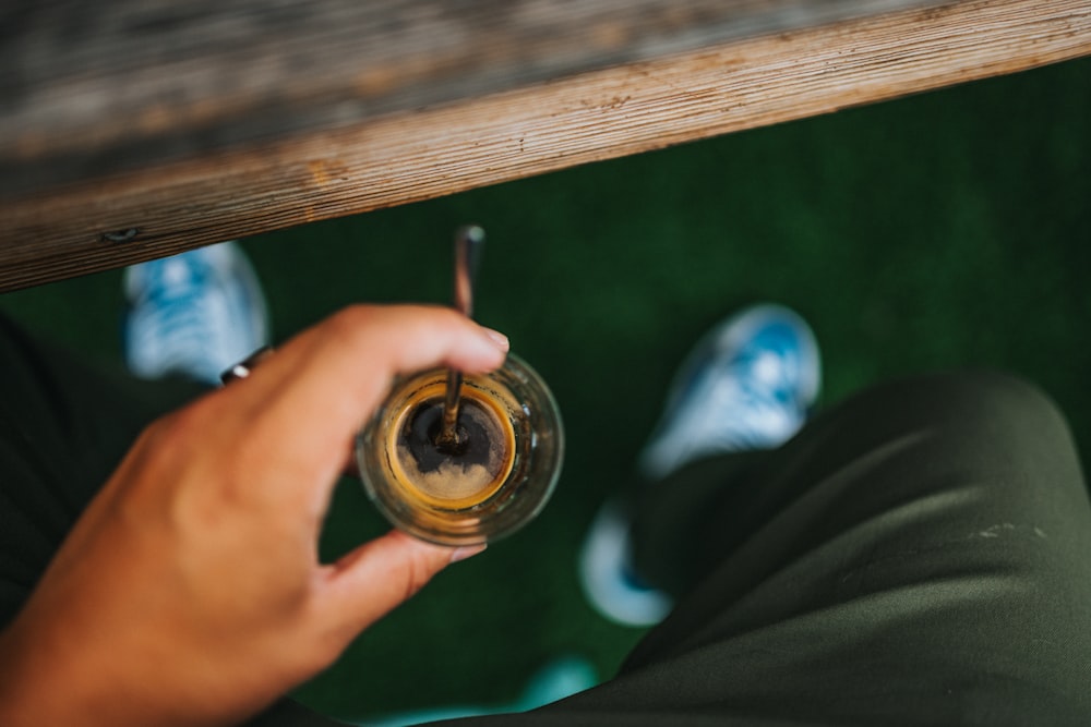 person holding clear glass jar