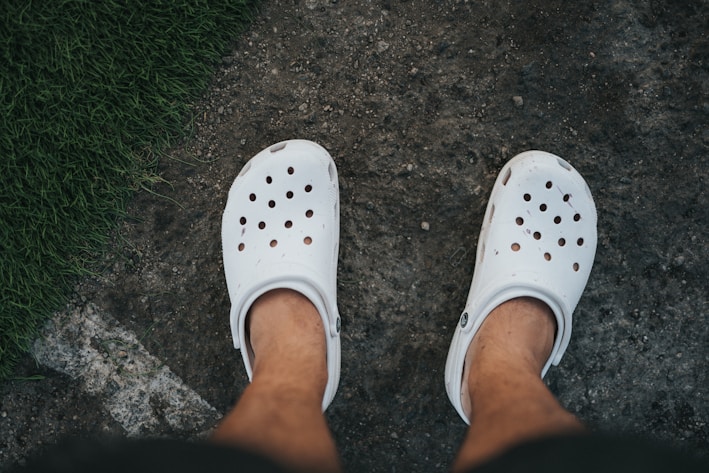 person wearing white rubber clog