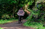 Zaza riding a whimsical bike through a sparkling, candy-colored forest.