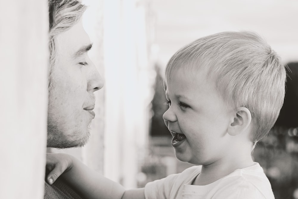 man and woman smiling in grayscale photography