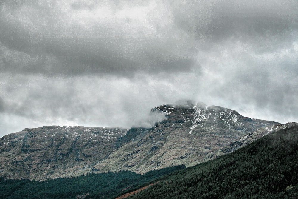 montaña verde y gris bajo nubes blancas