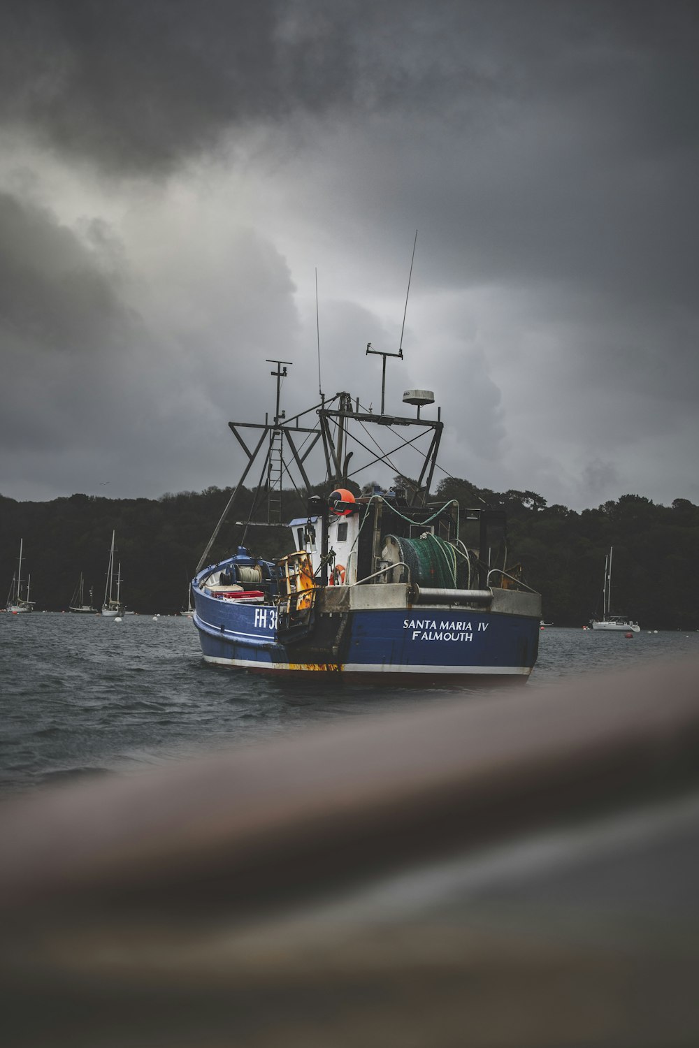 blue and white boat on sea under gray sky