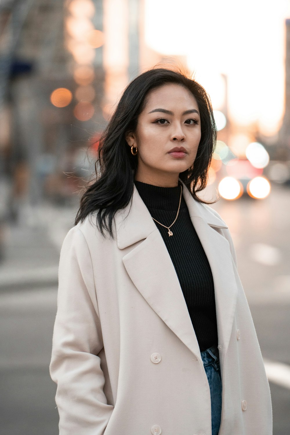 woman in white blazer standing on road during daytime