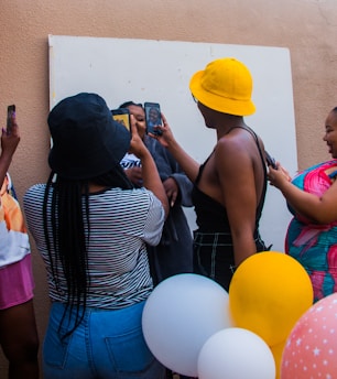 A group of friends smiling and using smartphones together in a bright, casual setting