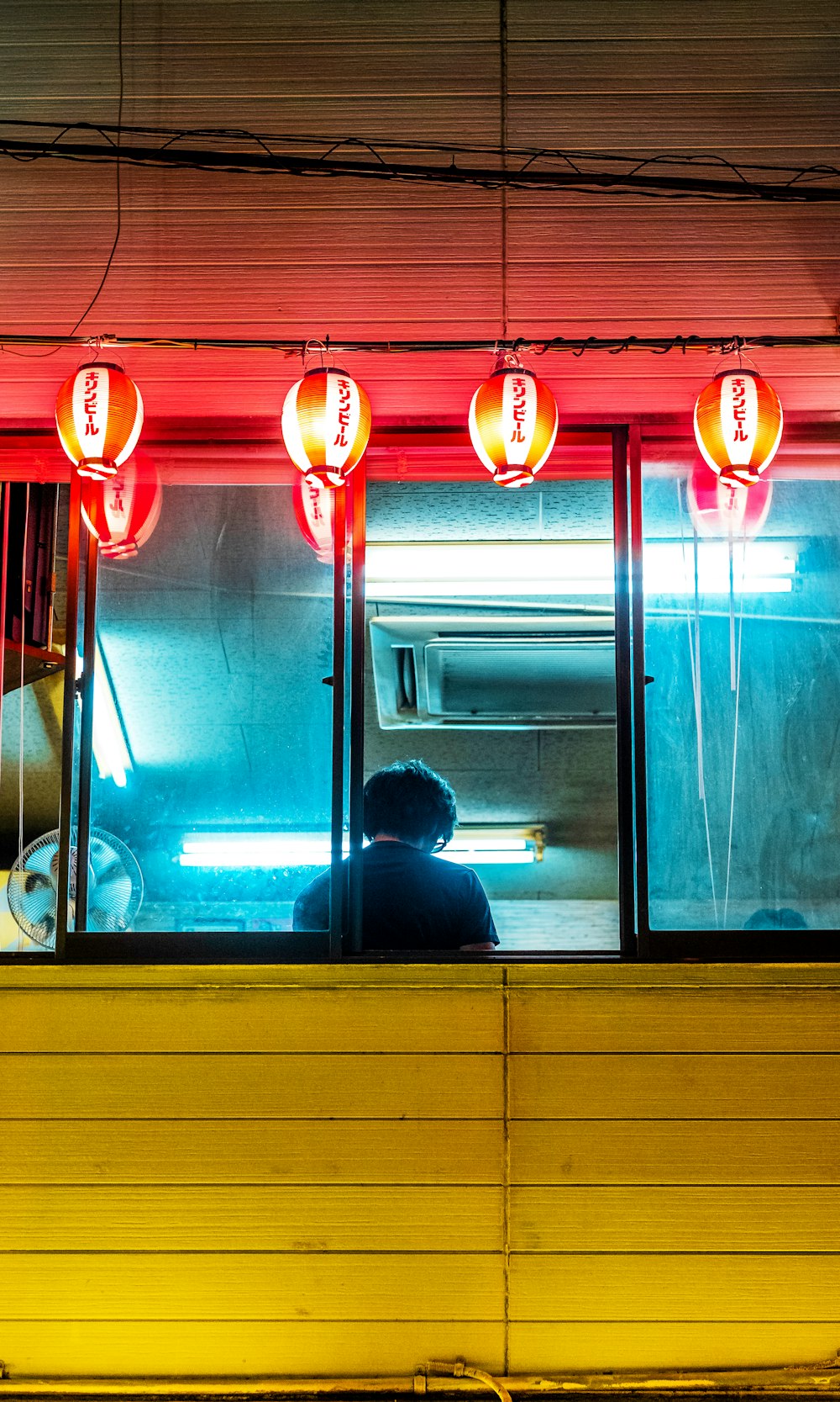 man in black jacket sitting on chair in front of window