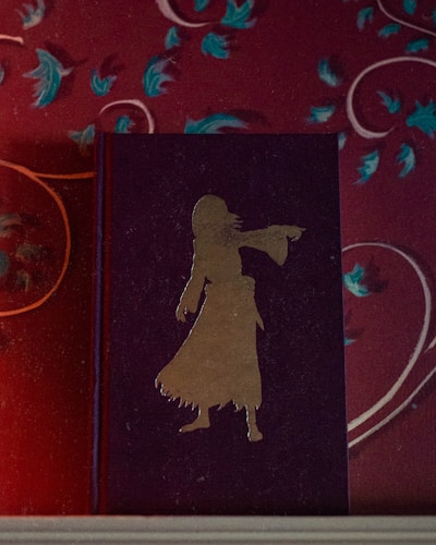 A mysterious violet-hued book cover with shadowy historical symbols glowing softly.