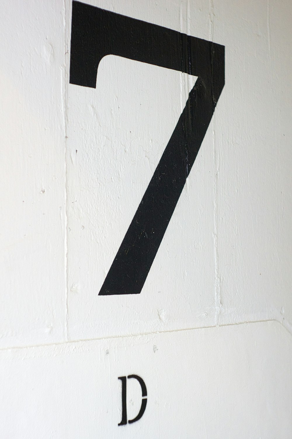 black arrow sign on white painted wall