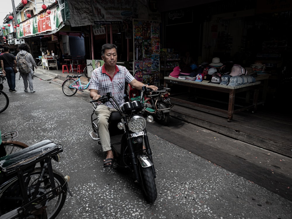 man in blue and white plaid button up shirt riding on black motorcycle during daytime