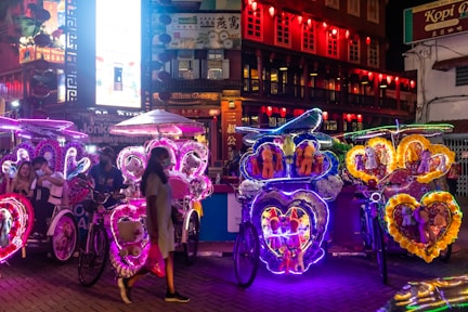people walking on street with balloons during night time