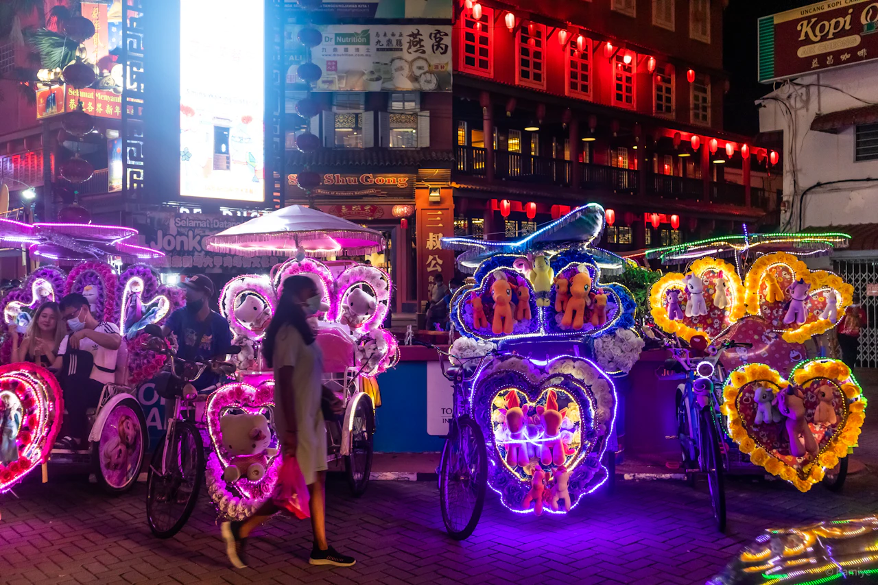 People walking on a street with balloons at night