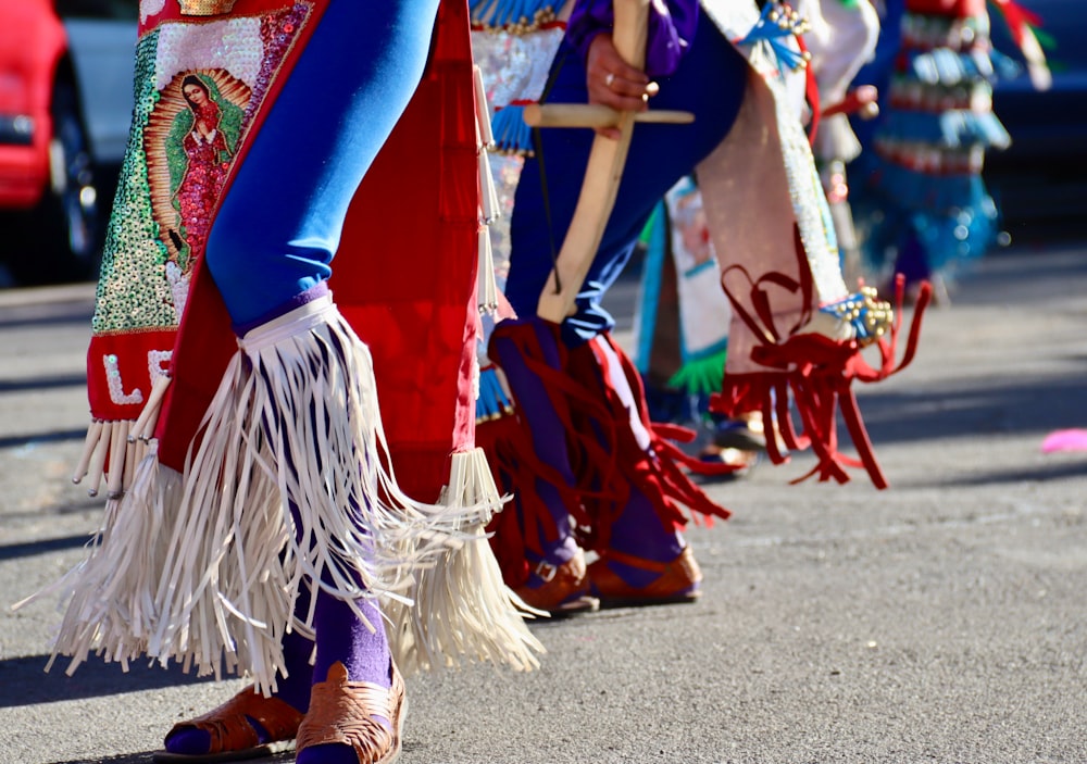 낮 동안 거리를 걷고 있는 파란색과 빨간색 긴팔 드레스를 입은 여자