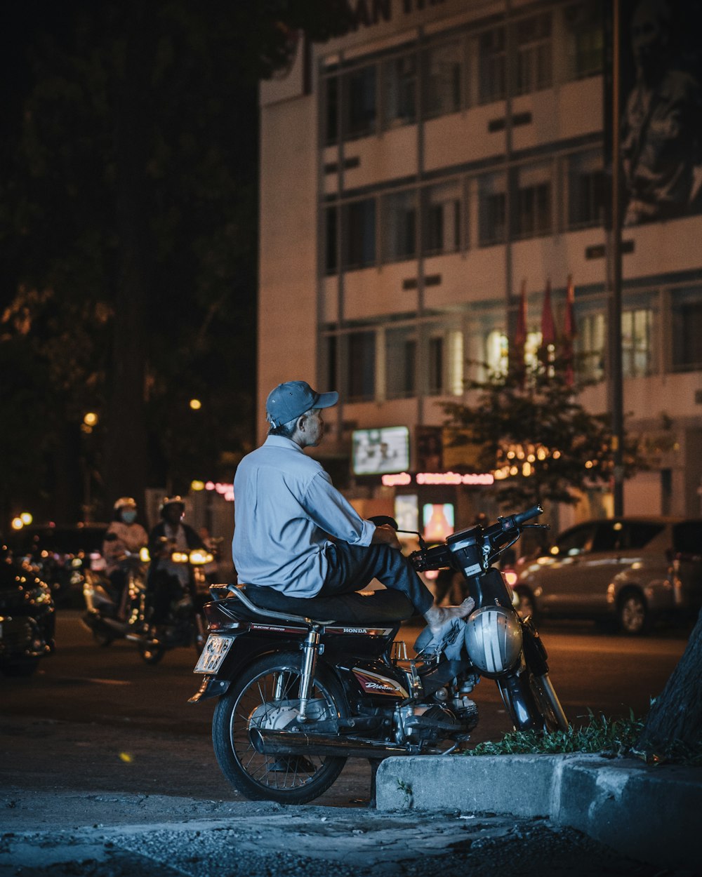 man in white jacket riding on motorcycle during night time