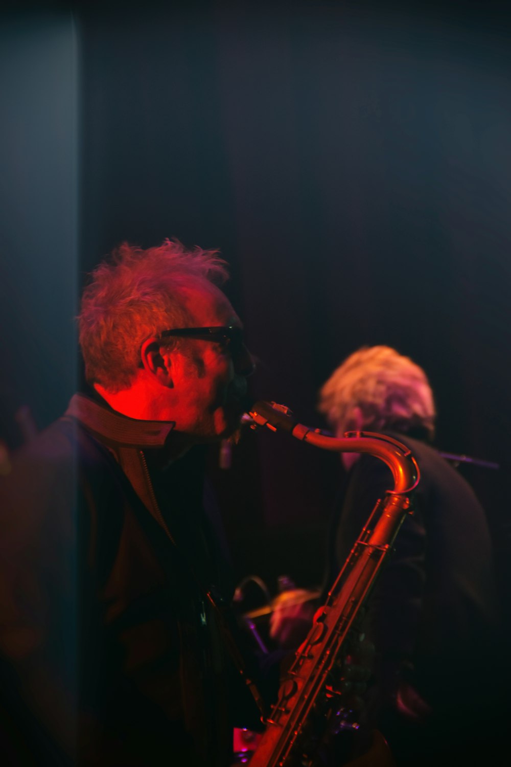 man in black suit playing saxophone