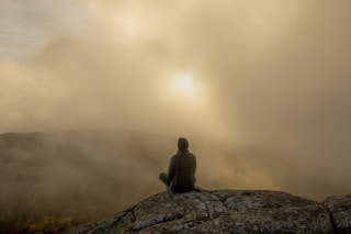 person sitting on rock during daytime