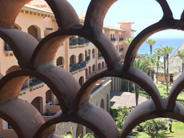 A charming beachfront apartment balcony with a view of palm trees and the Mediterranean.