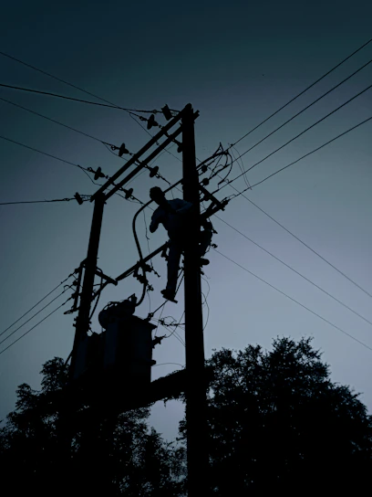 silhouette of electric post under cloudy sky during daytime