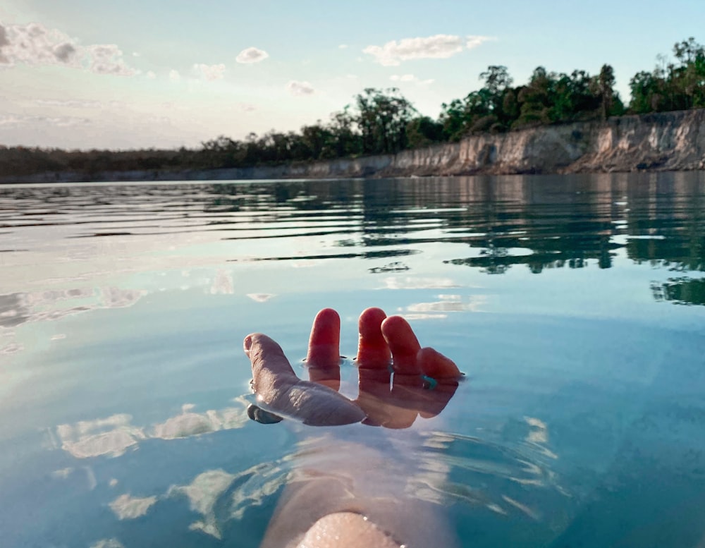 woman in blue bikini lying on the ground in the lake during daytime