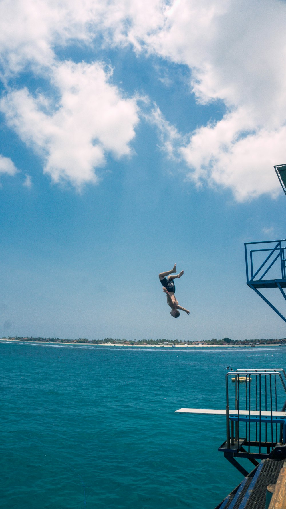 man jumping on the beach during daytime