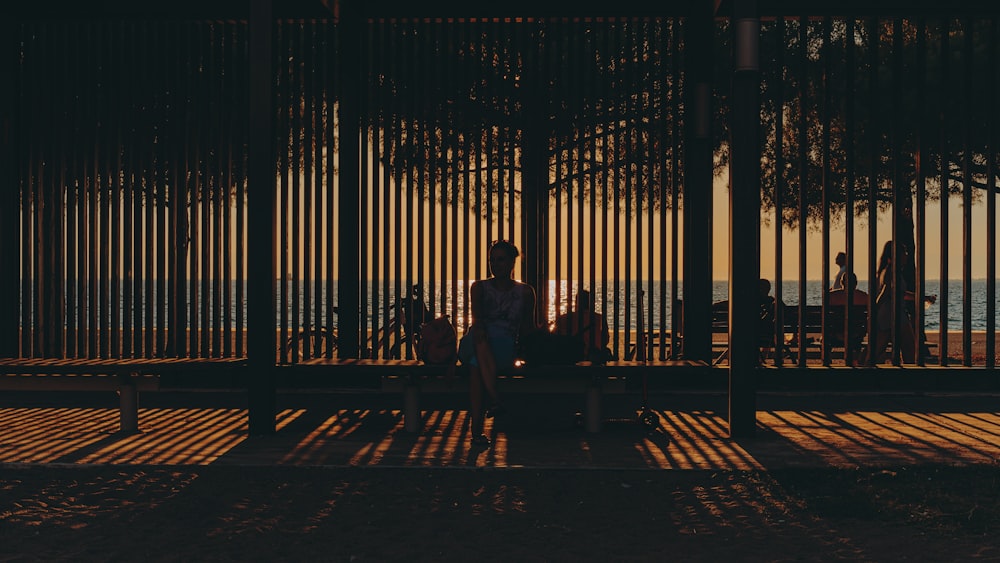 silhouette of 2 person sitting on bench