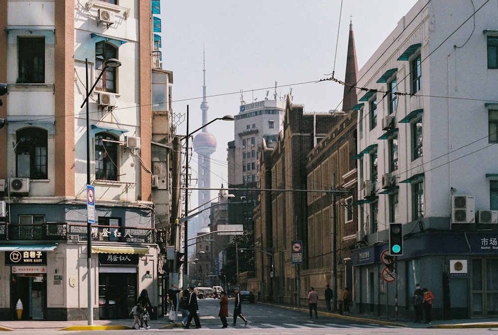 people walking on sidewalk near buildings during daytime