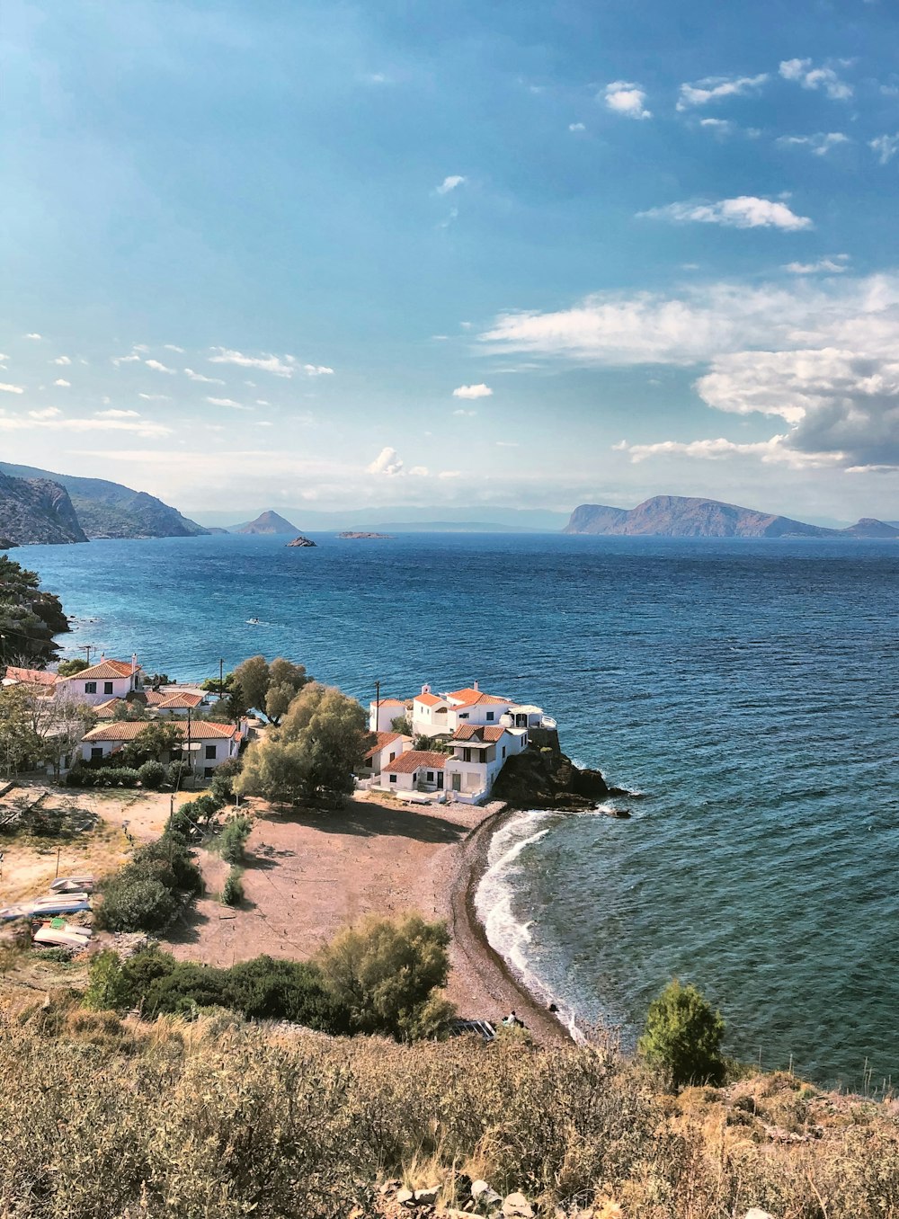 houses near body of water under blue sky during daytime