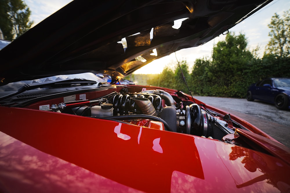 rotes und schwarzes Auto tagsüber unterwegs