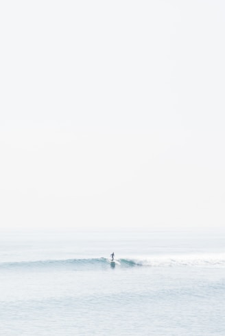 person surfing on sea waves during daytime