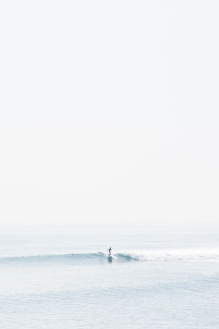 person surfing on sea waves during daytime