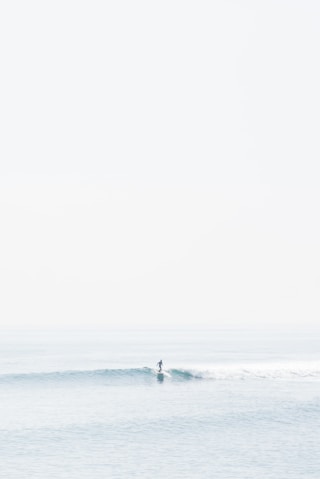person surfing on sea waves during daytime