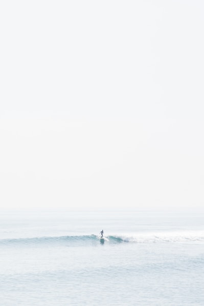person surfing on sea waves during daytime