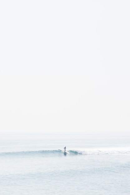 person surfing on sea waves during daytime