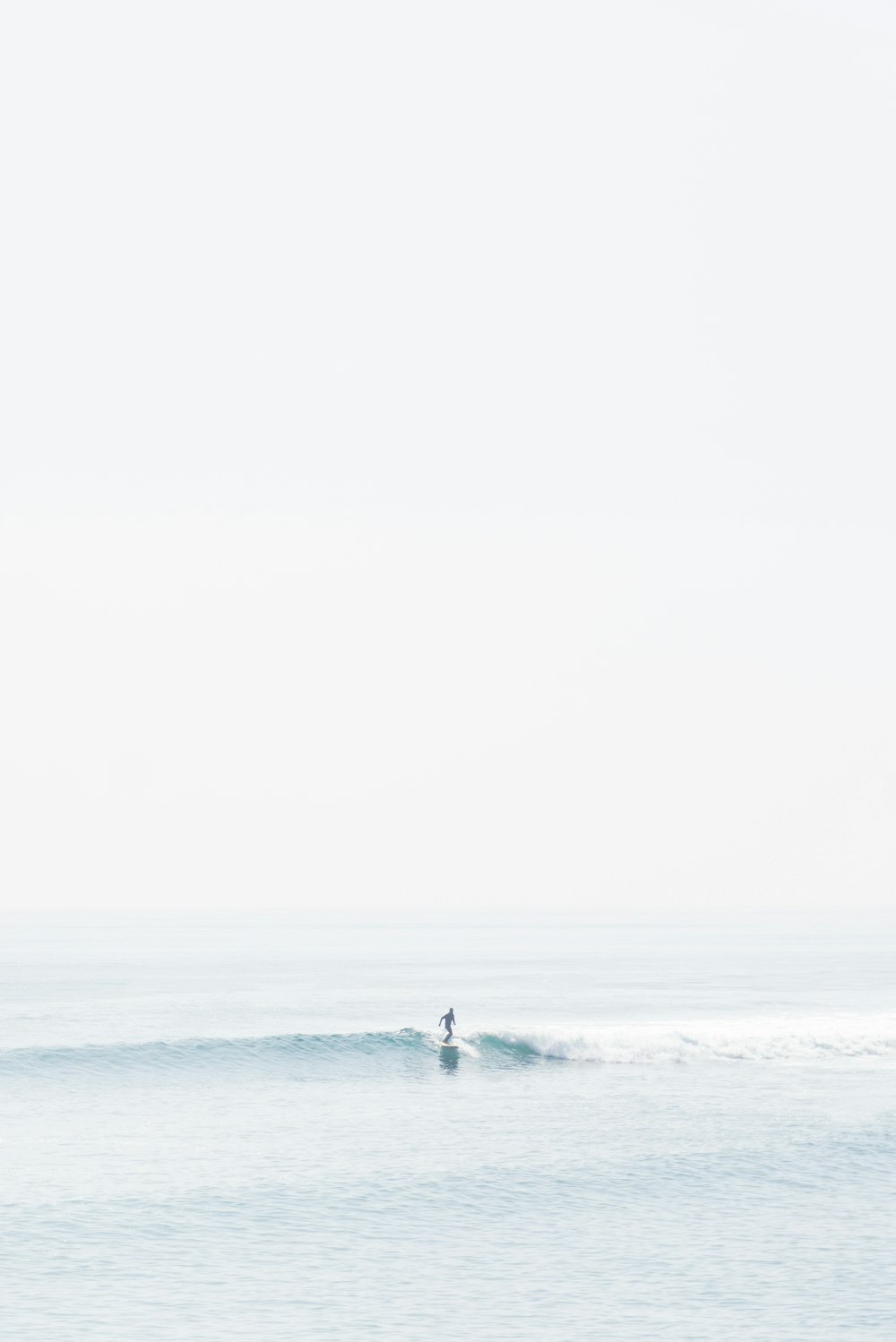 pessoa surfando nas ondas do mar durante o dia