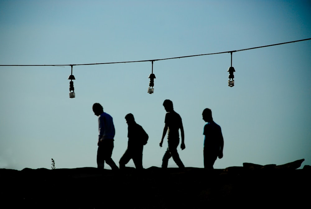 silhouette of people walking on street during sunset