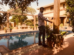 A friendly gardener and pool technician discussing plans in a lush backyard.