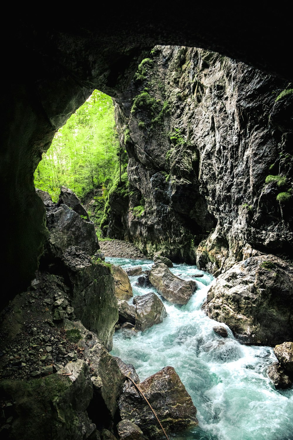 river in between green and brown rock formation during daytime