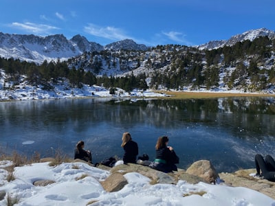people sitting on rock near lake during daytime andorra zoom background
